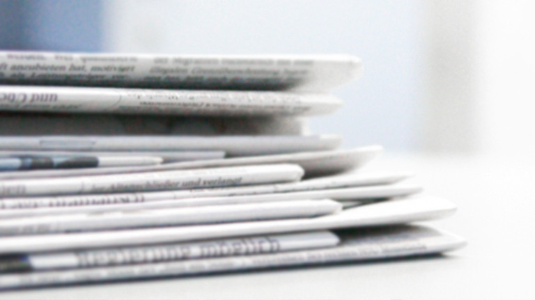 gestapelte Zeitungen mit den neusten Pressemeldungen